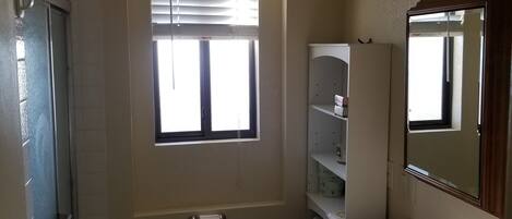 Ein kleines, kompaktes Badezimmer mit Toilette, Waschbecken und Fenster.