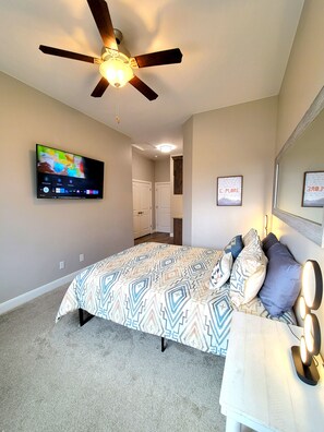 Relax in this inviting bedroom with a comfortable bed, bedside table, and mounted TV.