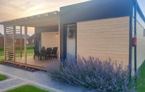 A modern house with a covered patio, a dining area, and a garden with lavender. - Awesome home in Jezierzany with sauna (Jezierzany)