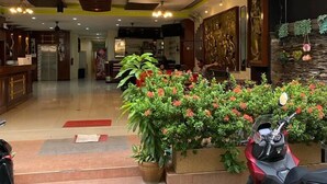 A hotel lobby with a reception desk, a potted plant, and a parked scooter. - Lavender Patong Hotel (Patong)