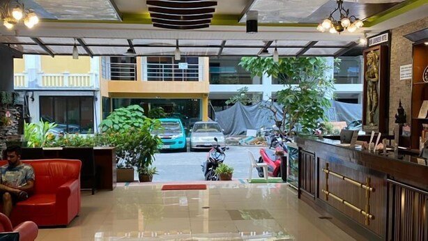 A spacious lobby with a modern design, featuring a reception desk, seating area, and a view of the street outside. - Lavender Patong Hotel (Patong)