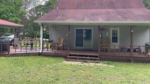 A small house with a porch, a covered patio, and a garage. - Hummingbird Haven-3 Bed 2 Bath River House (Clifton)