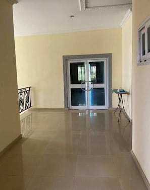 Enter a tranquil space with a door featuring a glass panel, flanked by a small table and chair.