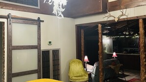 Une pièce avec un lit, une chaise, un lustre et une vue sur une autre pièce.