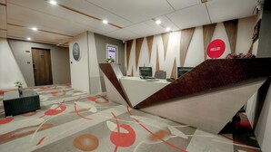 A modern hotel reception area with a desk, computers, and a 'Hello!' sign. -  Zip By Spree Hotels Surat (Surat)