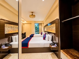 Habitación de hotel con una cama grande, mesitas de noche, un escritorio y vistas al exterior.