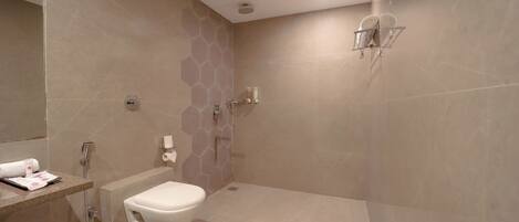 A modern bathroom with a toilet, shower, and a towel rack.
