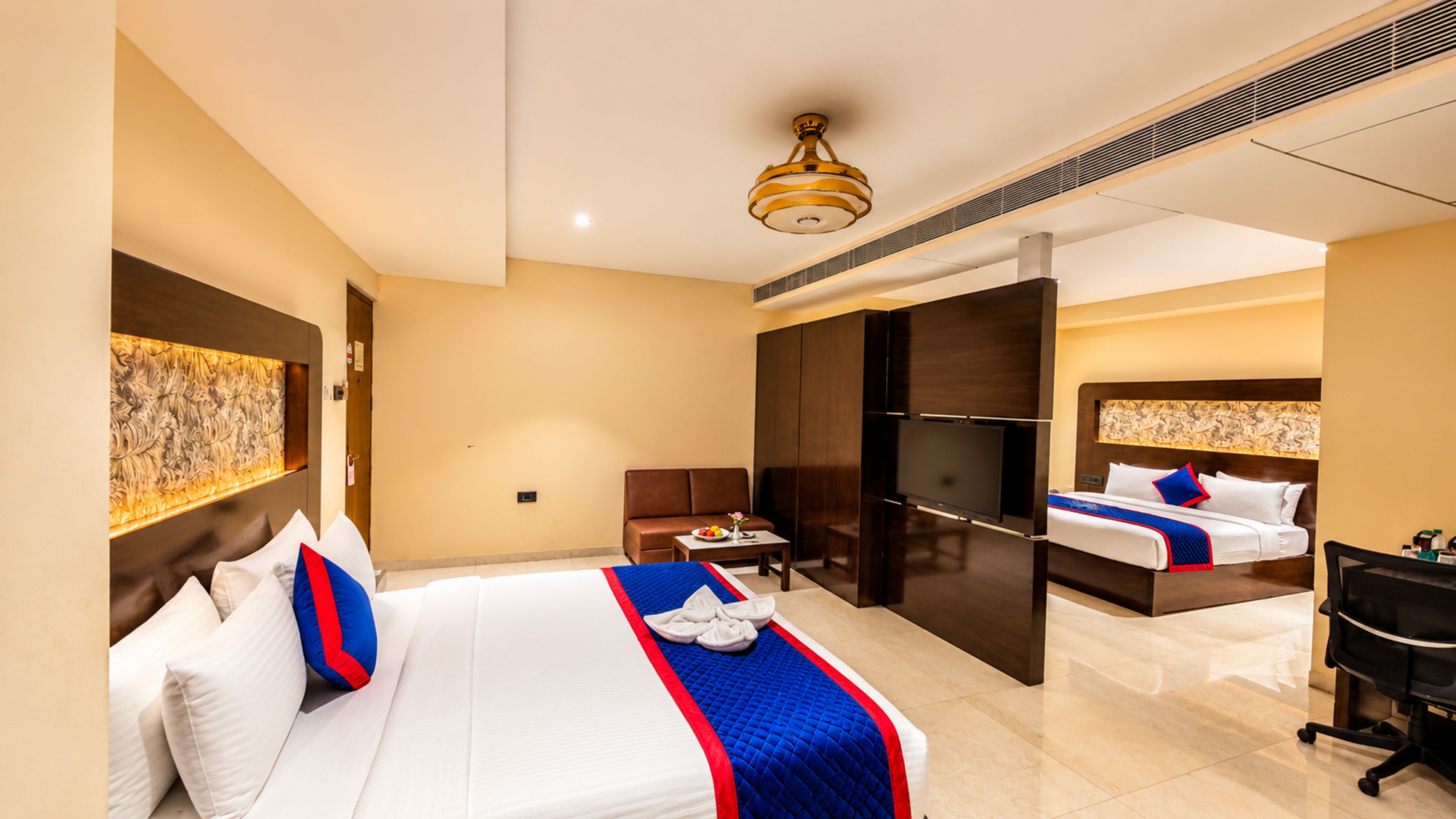 Une chambre d’hôtel avec un grand lit, un bureau, une chaise et une télévision.