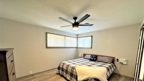 A bedroom with a bed, a ceiling fan, and a window. - The Hideaway Oliver Springs, Only Min from Windrock Park (Oliver Springs)