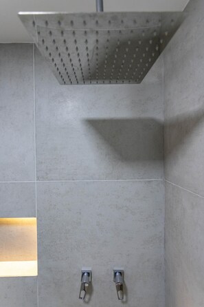 A shower with a perforated ceiling, two wall-mounted controls, and a recessed light. - Apartment in Copacabana Suite Bi204 (Rio de Janeiro)