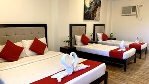 A hotel room with two beds, each with red and white bedding, and a swan-shaped towel on the beds. - Davao Airport View Hotel (Davao)