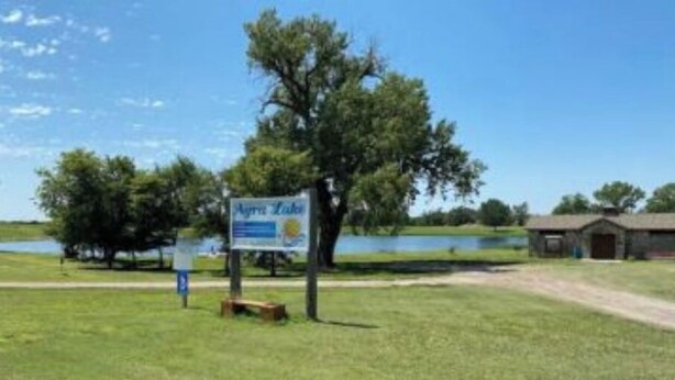 A grassy area with a sign that reads "Agua Azul." - Large home 2 living rooms, 4 bedrooms. Near lakes and great hunting and fishing. (Agra)