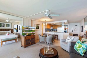 Une chambre d’hôtel équipée d’un lit, d’une télévision, d’un coin repas et d’une kitchenette.