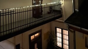Un edificio de varios niveles con un balcón, una puerta y una ventana.