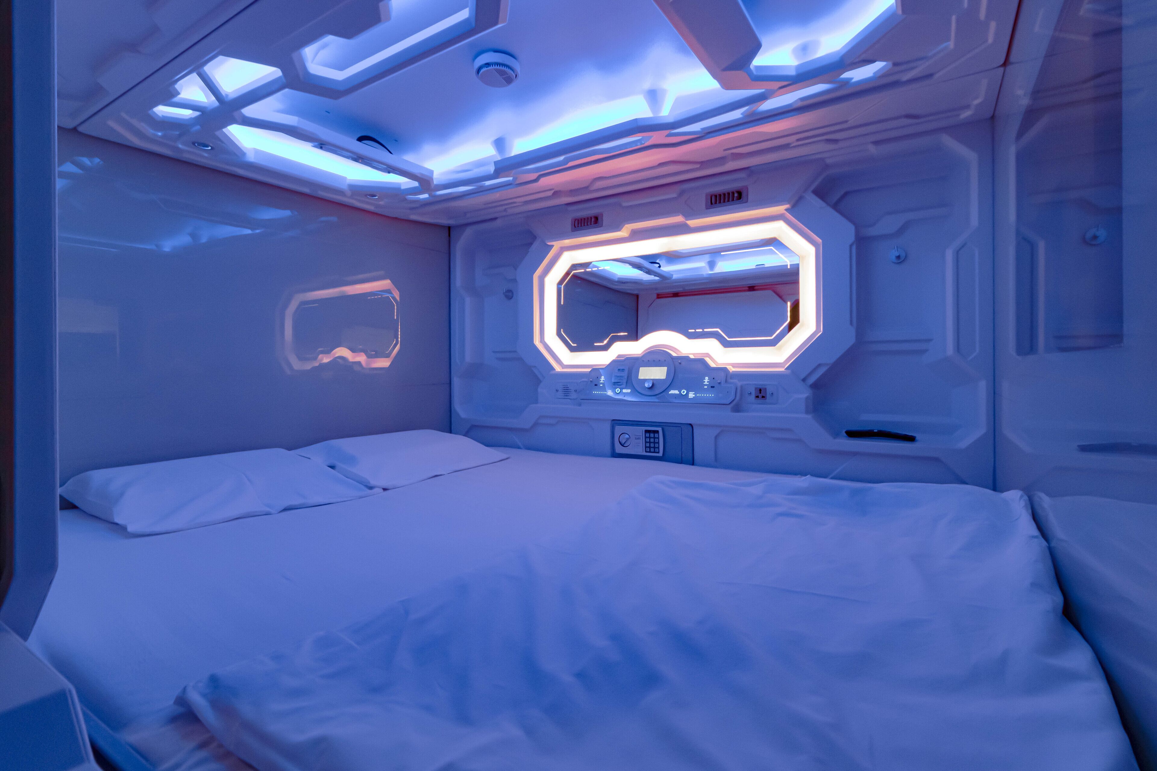 Ein futuristisches Zimmer mit Bett, Bedienfeld und einem einzigartigen Deckengestaltung.