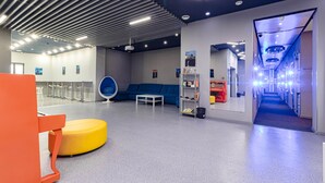 Een modern interieur met een zithoek, een receptiebalie en een gang die naar een trap leidt.