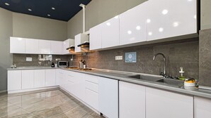 Een moderne keuken met witte kasten, een roestvrijstalen spoelbak en een betegelde spatwand.