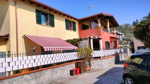 A two-story building with a red awning and a stone wall.