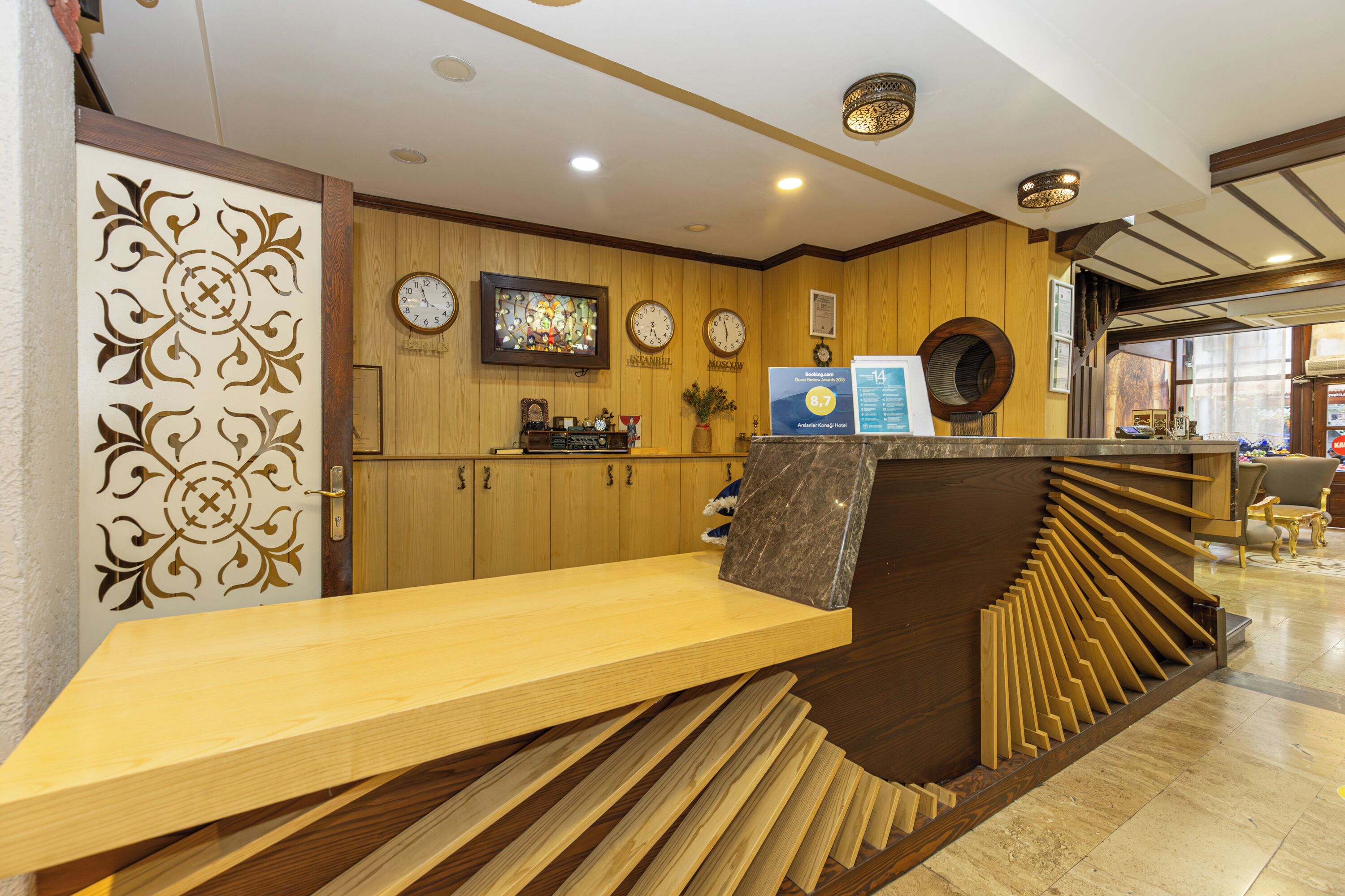 A reception area with a wooden reception desk, a clock, and a stained glass window.