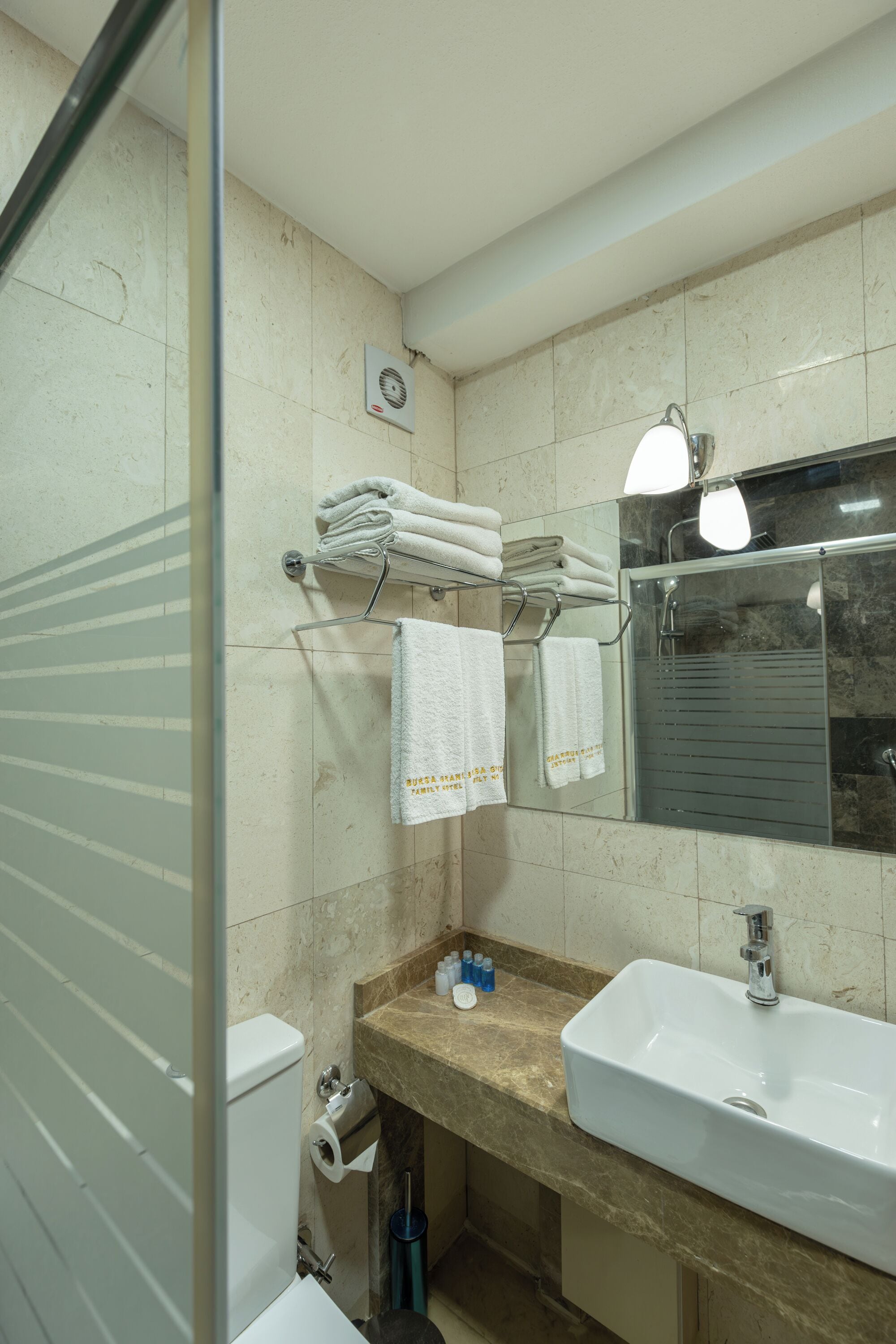A bathroom with a sink, mirror, and towel rack.