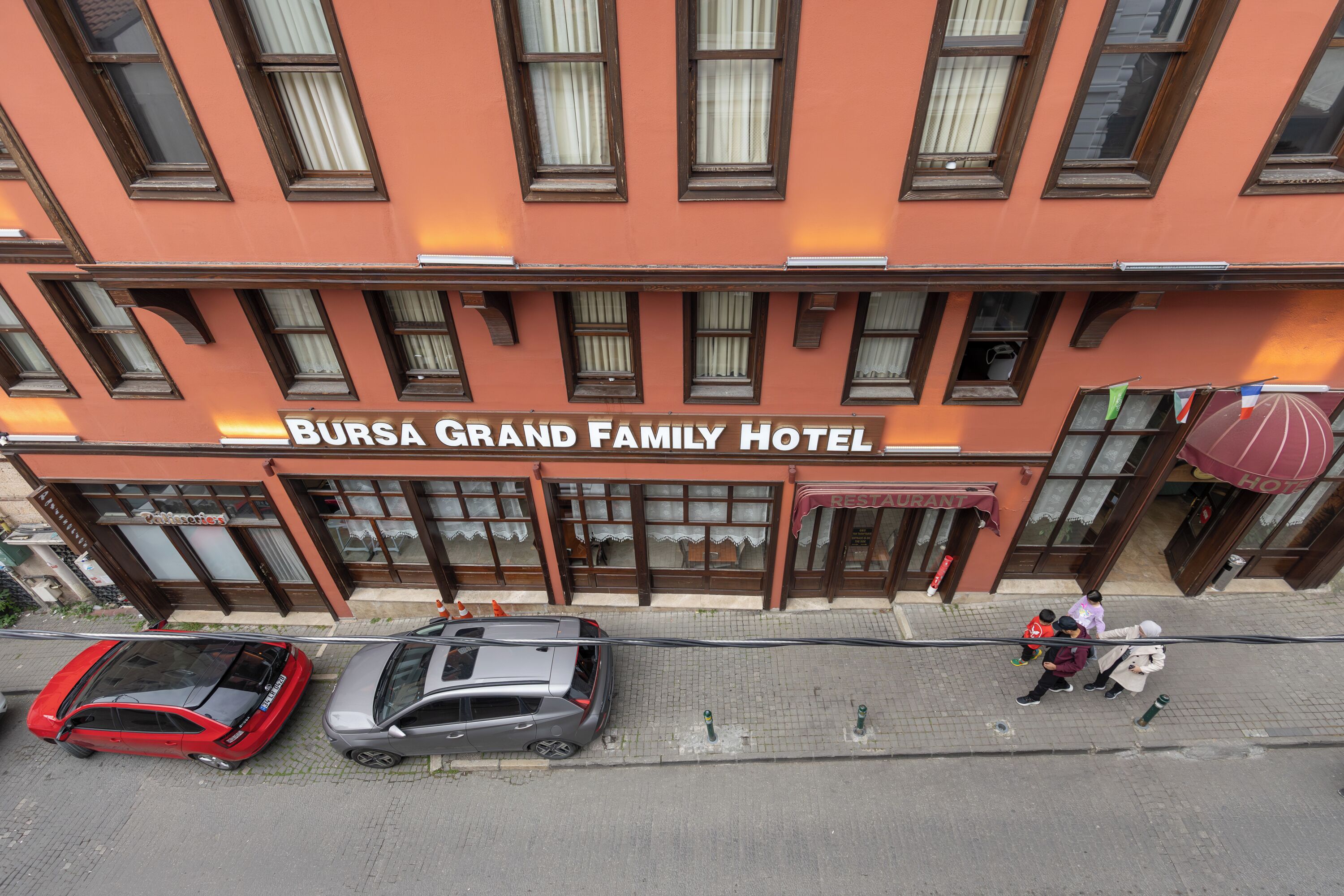 The Bursa Grand Family Hotel facade with multiple windows and a restaurant sign.