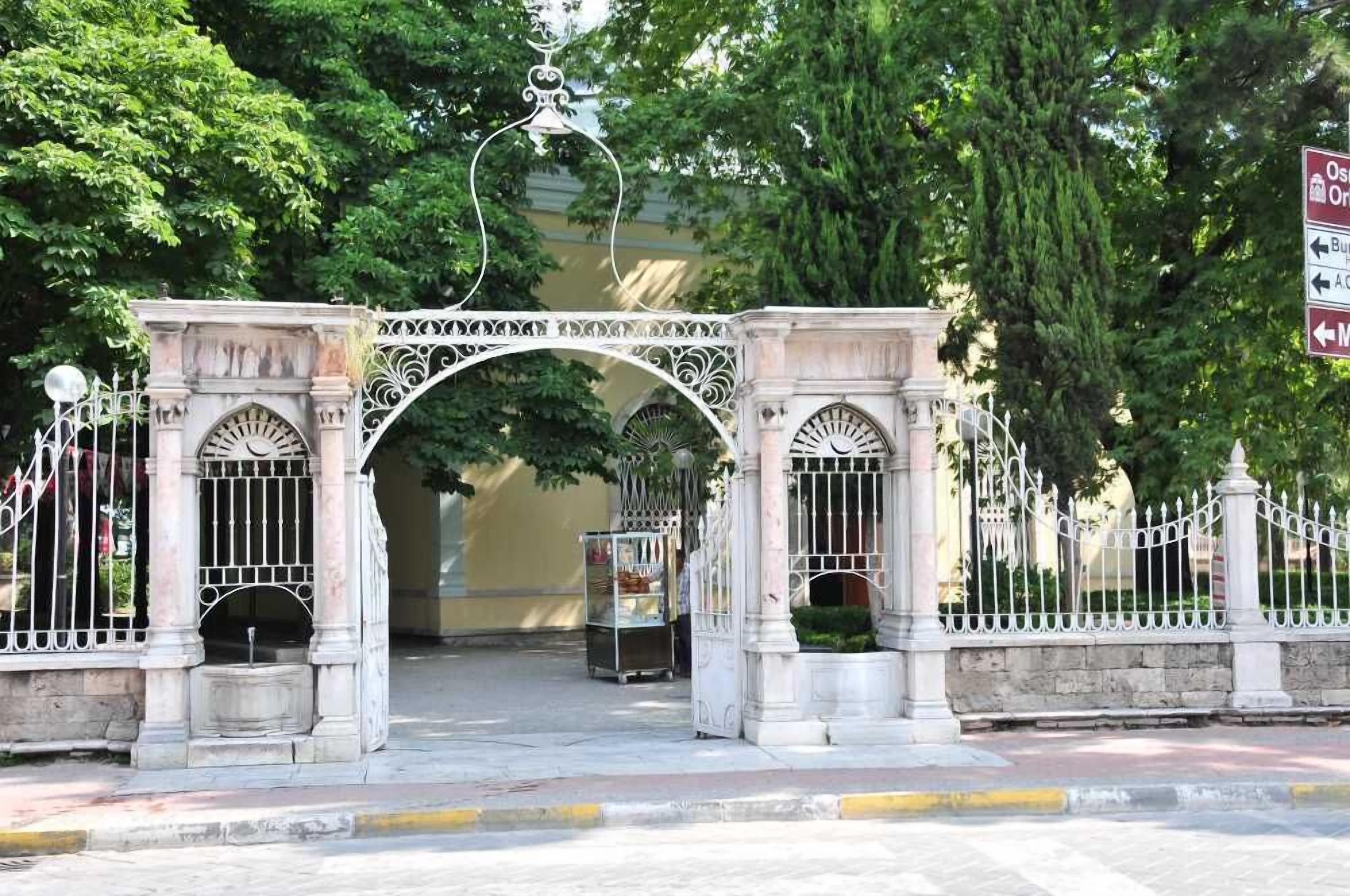 Una puerta ornamentada con un arco central, flanqueada por dos columnas, que da paso a la entrada de un edificio.