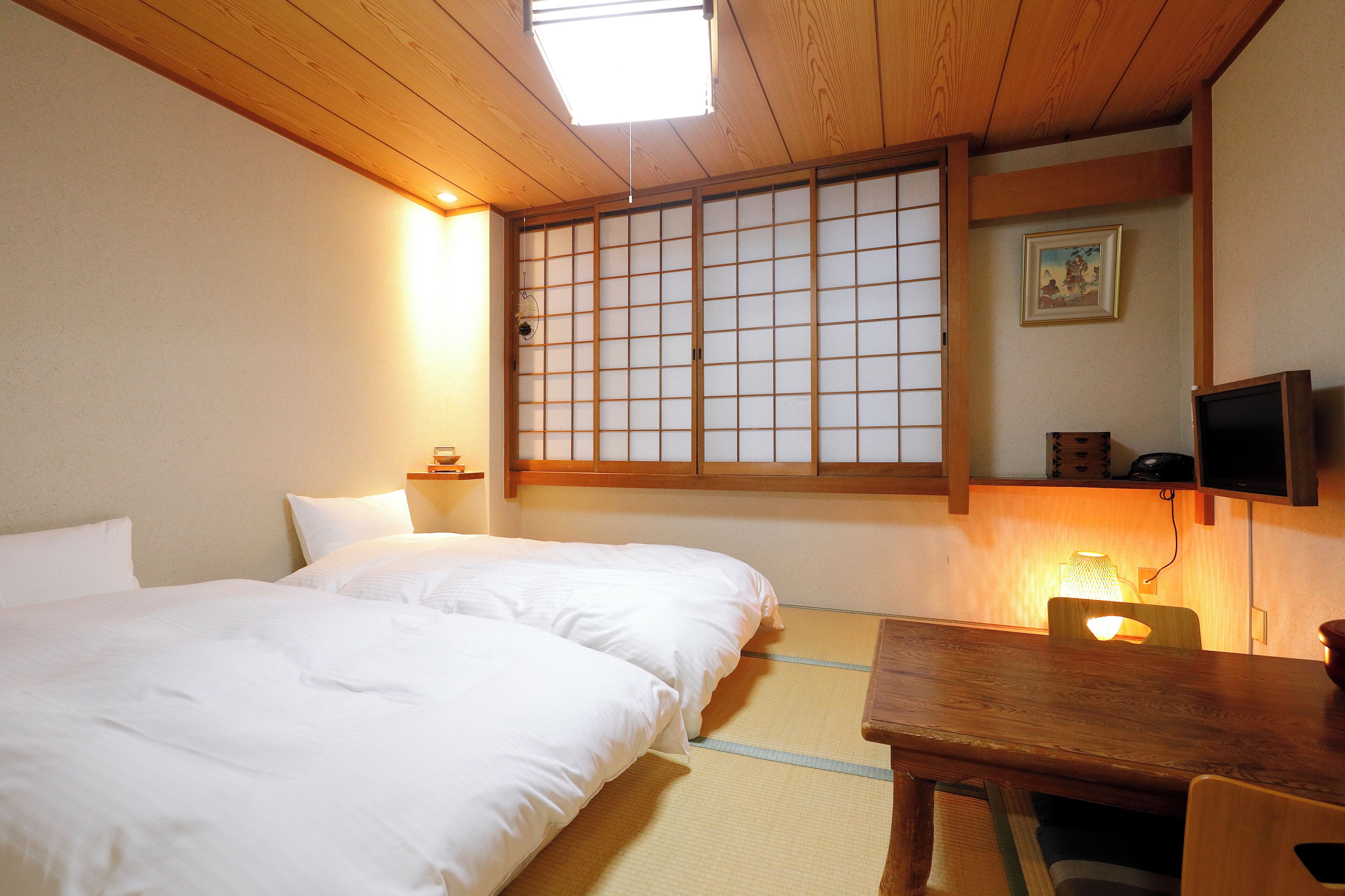 A traditional Japanese room with tatami flooring, a low wooden table, and a sliding door with a grid pattern.