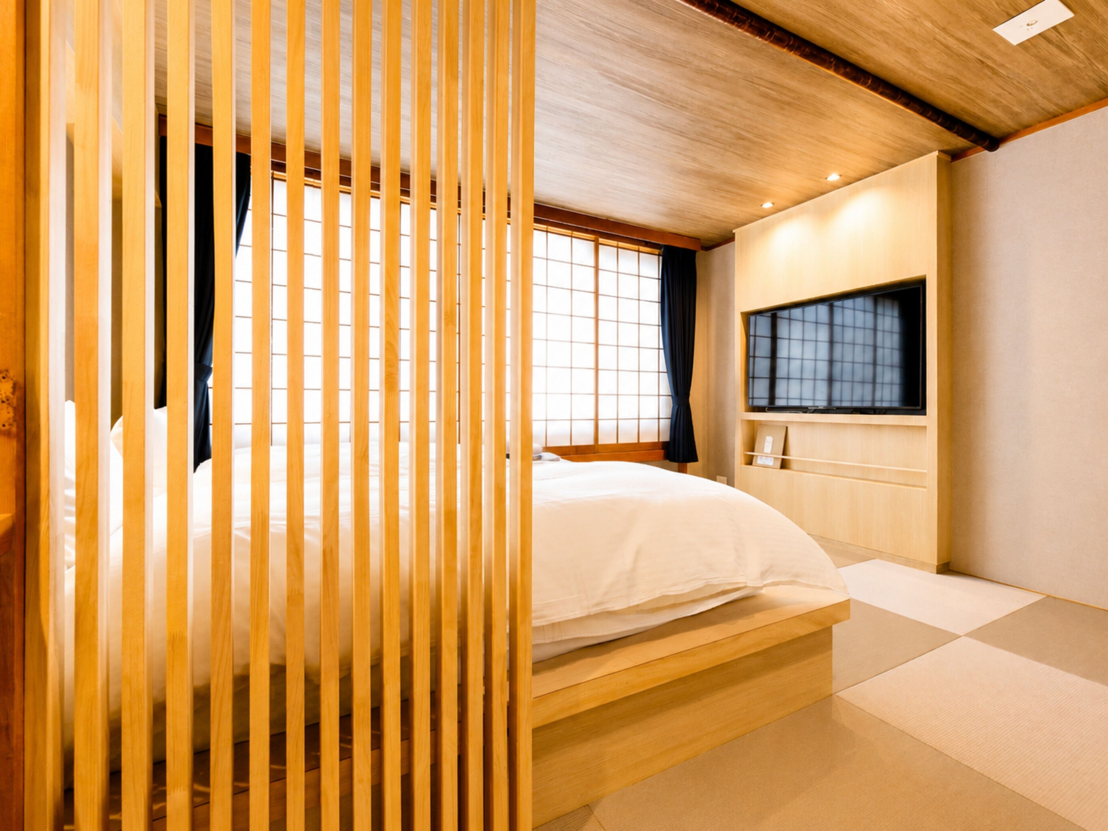 A room with a bed, a window, and a television.
