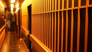 A hallway with wooden paneling and a wooden floor. - Nara Ryokan (Nara)