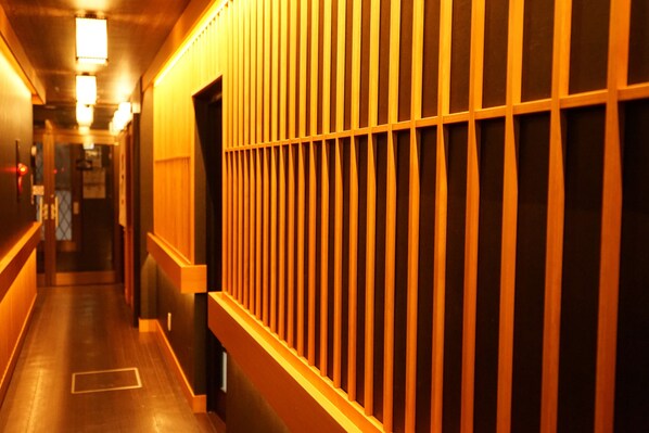 A hallway with wooden paneling and a wooden floor. - Nara Ryokan (Nara)