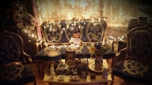 A cozy seating area with a sofa and chairs, a table with various items, and string lights. - Room in a beautiful rural house from the 17th century in Cuenca. (Valeria)