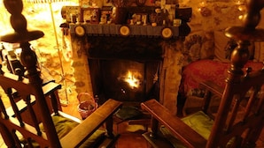 A cozy room with a fireplace, wooden furniture, and a checkered tablecloth. - Room in a beautiful rural house from the 17th century in Cuenca. (Valeria)