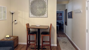 A dining area with a table and chairs, a floor lamp, and artwork on the walls. - Historic Townsend Park bungalow minutes from Black Canyon National Park (Montrose)