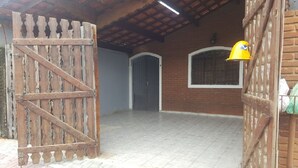 Een ruime binnenruimte met betegelde vloer, houten poort en bakstenen muur.