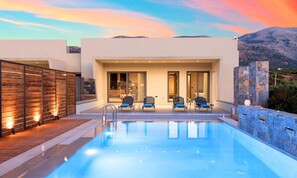 Ein moderner Poolbereich mit freiem Blick auf den Pool, Liegestühlen und einer Steinmauer.