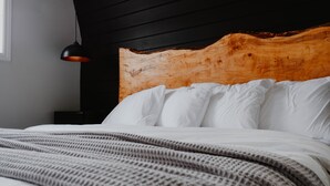 A bed with white linens and a wooden headboard.