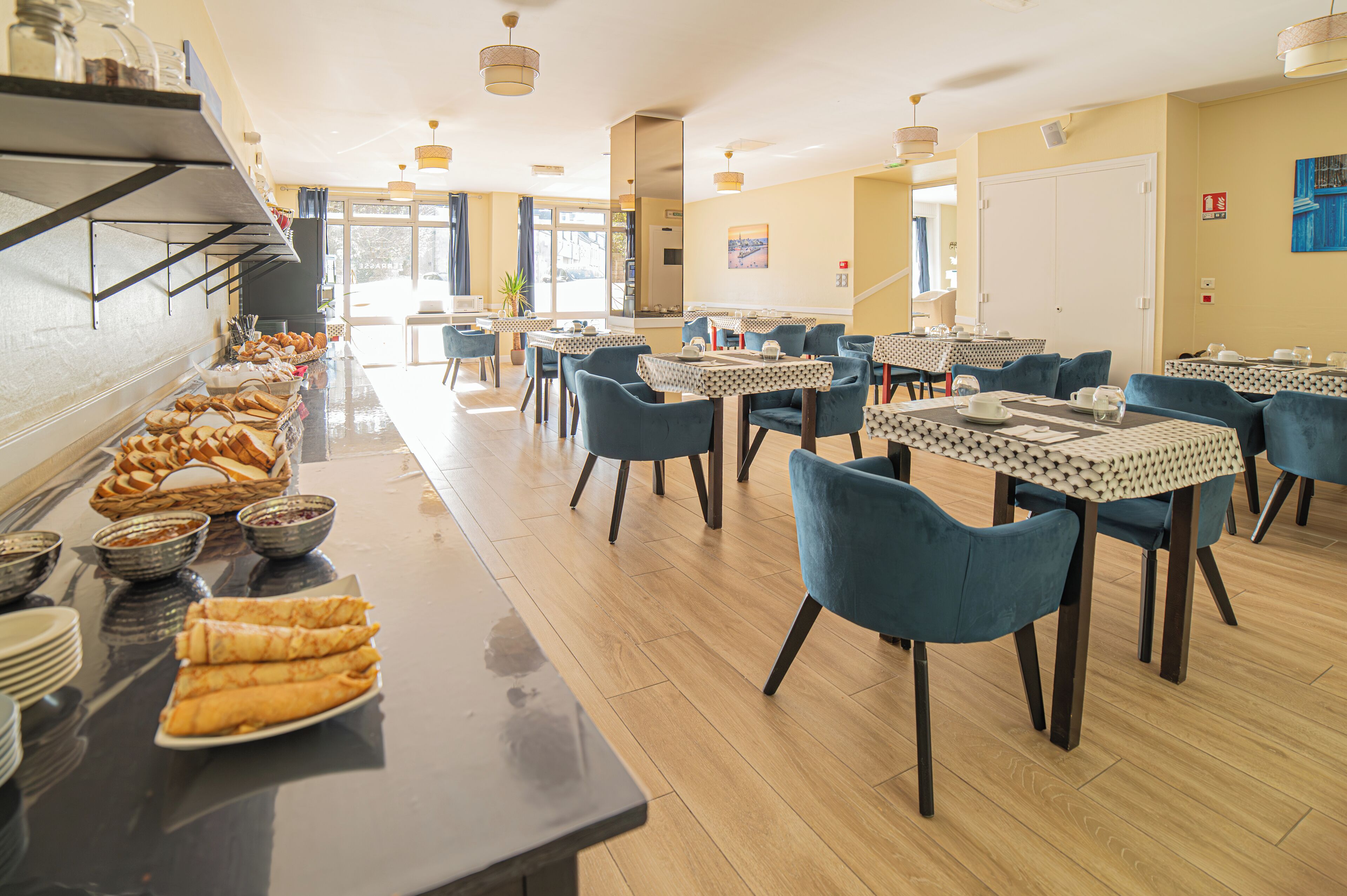 Uma área de buffet com diversas opções de comida e mesas com cadeiras.