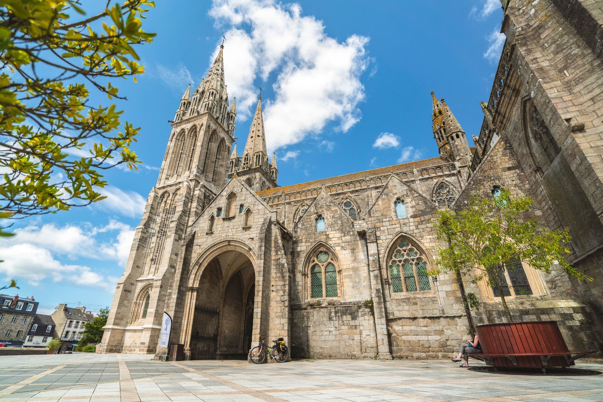 A historic cathedral with two tall spires, large arched entrances, and a stone facade.