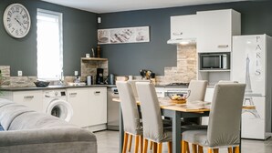 Eine moderne Küche mit Essbereich, einer Waschmaschine und einem Kühlschrank mit Design von Paris’ Eiffelturm.