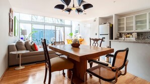 A modern kitchen with a wooden dining table, chairs, and a ceiling fan.