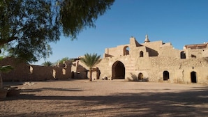 Un ancien bâtiment en pierre, doté de nombreuses arcades et d’une cour intérieure.