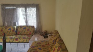Una sala de estar con un sofá, una mesita y un autobús de juguete.