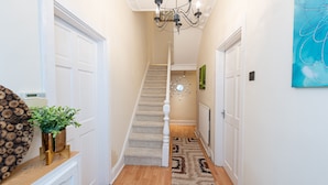 A hallway with a wooden floor, a staircase, and a chandelier. - Large and spacious 5 bedroom house in the heart of Liverpool (Fairfield)