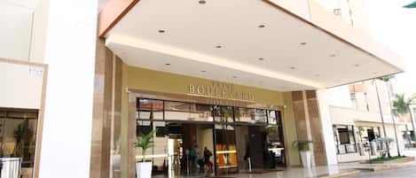 Entrada de hotel con porche cubierto, puertas de vidrio y un cartel que dice 'Boulevard Suite Hotel'.