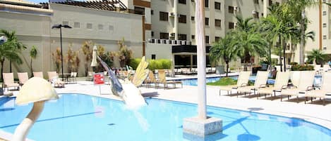 Una piscina al aire libre, sombrillas, tumbonas