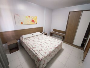 A hotel room with a bed, bedside tables, a bench, a wardrobe, and a wall art piece. - Thermas Boulevard (Caldas Novas)