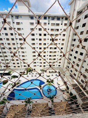 A high-rise hotel with multiple floors, a pool area with two pools, and outdoor seating. - Thermas Boulevard (Caldas Novas)