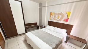 A hotel room with a bed, bedside table, and a mirror. - Thermas Boulevard (Caldas Novas)