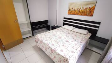 Un dormitorio con una cama, una mesita de noche, un armario y un cuadro en la pared.