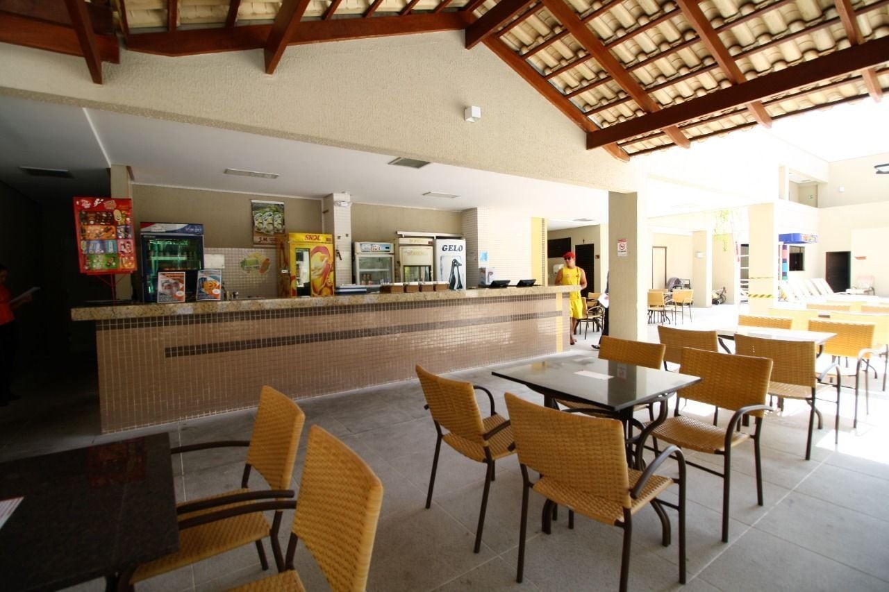 Un ristorante con un bancone piastrellato, sedie in vimini e pavimento in piastrelle.